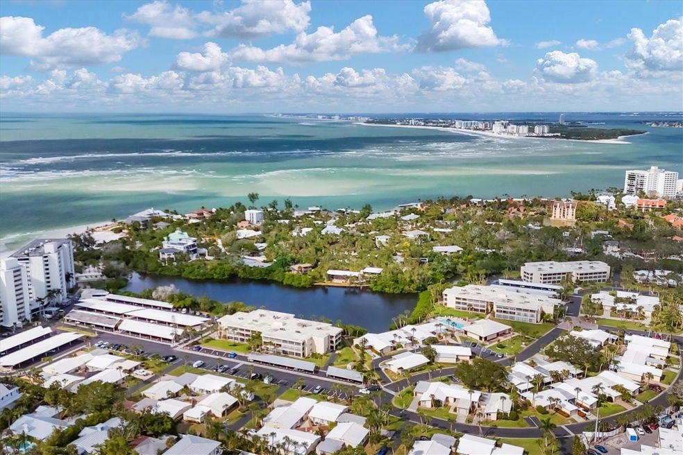 Aerial view of a coastal Florida community with water, roads, and low-rise buildings