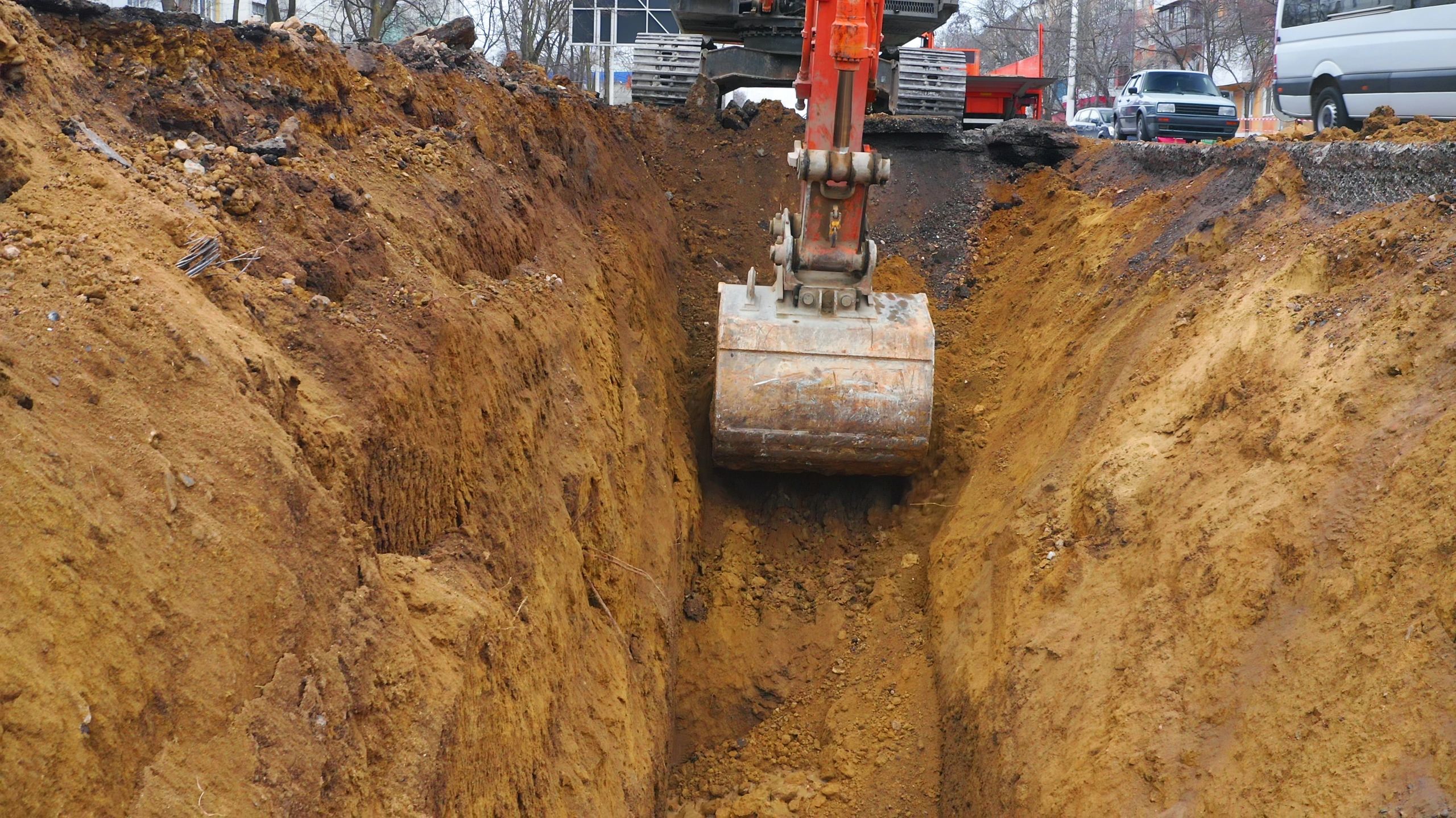 Excavator digging trench for underground utility installation